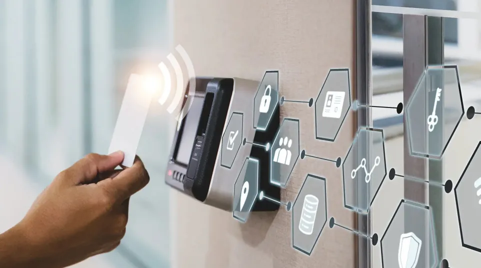 Person holding a card near a digital access control panel with security and data icons in a modern office.