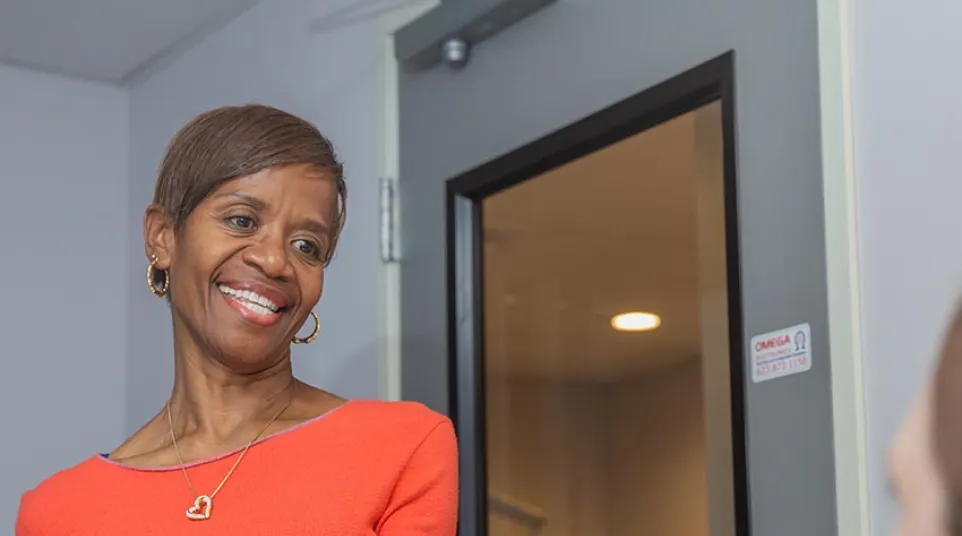 Dentist showing dental mold to elderly woman during consultation in bright dental office.