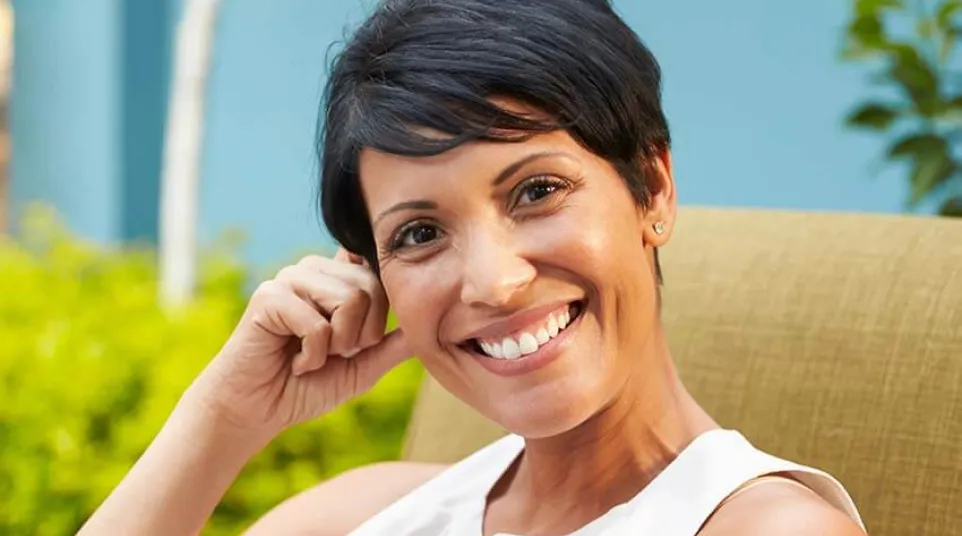 a woman smiling with her hand on her chin