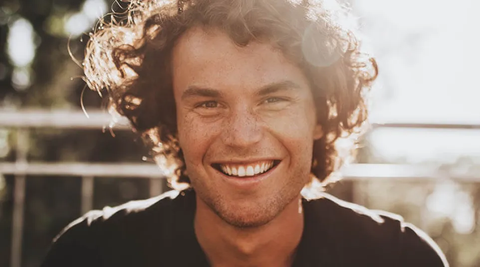 a person with curly hair smiling