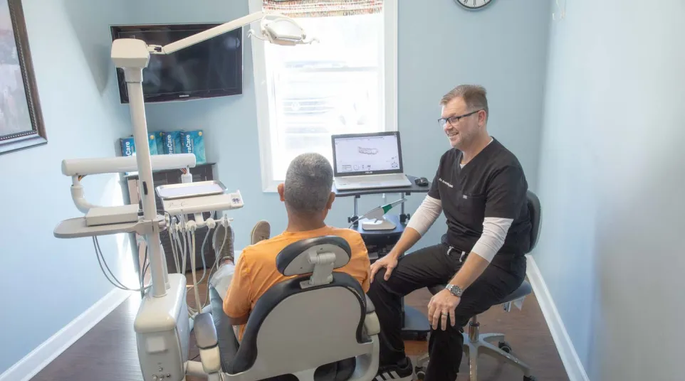 Dr. Scott Fitts chats with a male patient inside his dental office