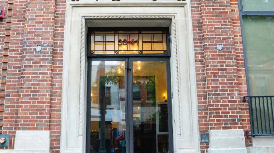 Entrance to River Vie Historical Plaza II with glass doors set in a brick building facade under decorative signage.