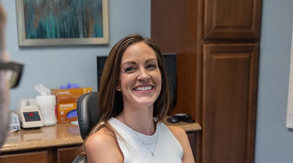 a dark haired patient smiles to Dr. Scott Fitts inside his dental office