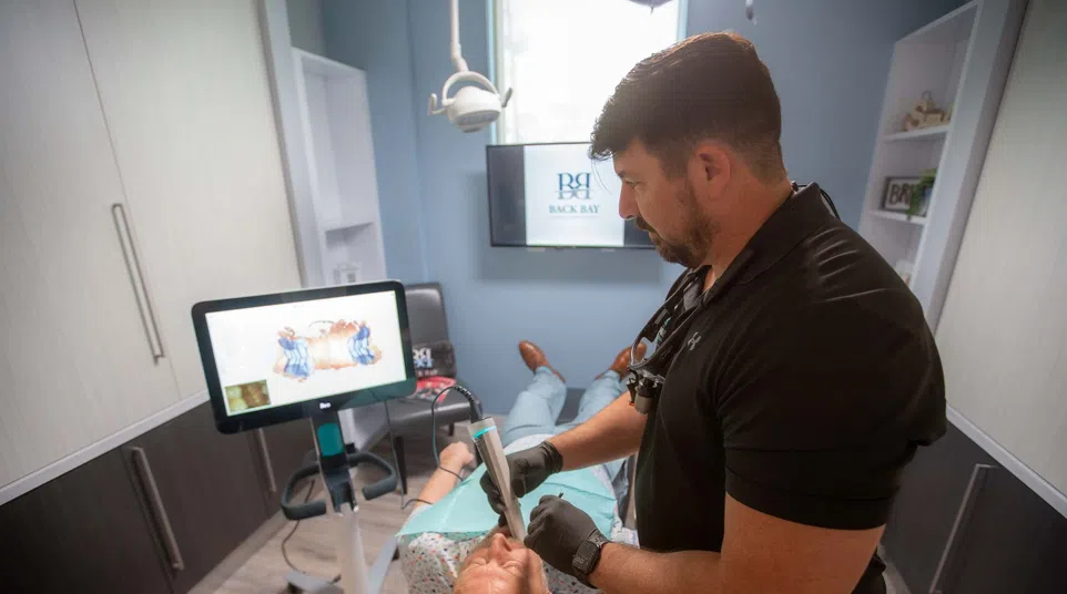 Dentist performing a dental scan on a patient in a modern dental office with digital technology.