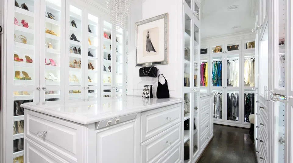 Luxurious walk-in closet featuring elegant shoes, a chic vanity, and organized clothing racks.