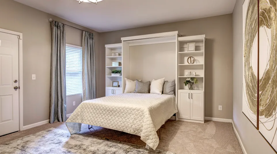 Bedroom with a wall bed or murphy bed with built-in shelves and cabinets, white comforter and pillows and an accent rug
