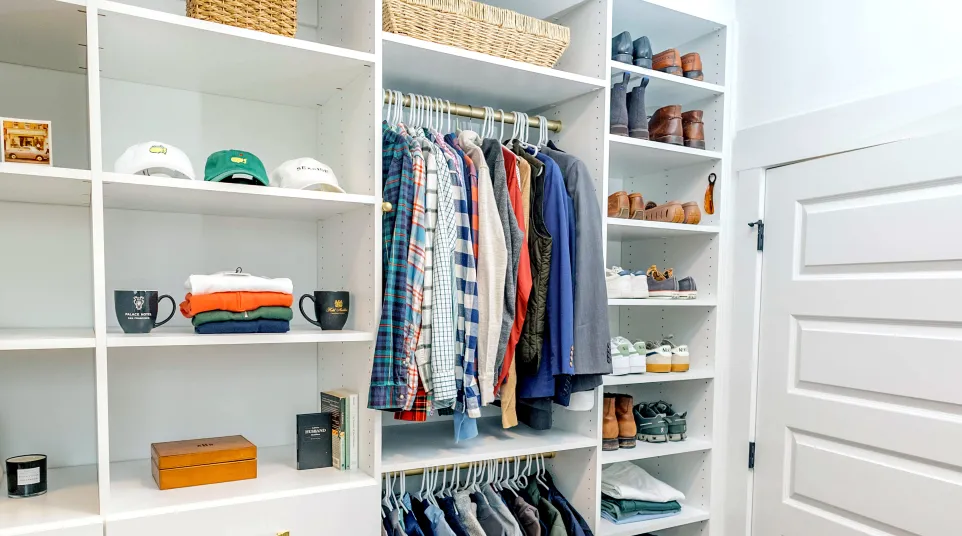 a closet with a white door and shelves with clothes