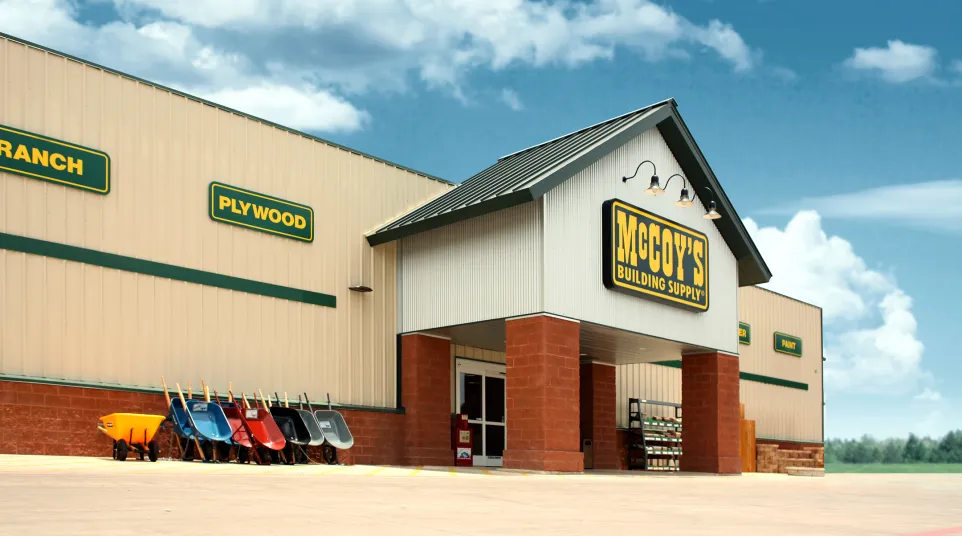 McCoy's Building Supply store exterior with stacked wheelbarrows and clear sky background