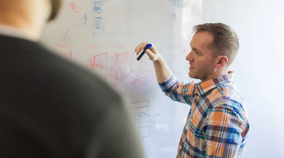 a man writing on a whiteboard