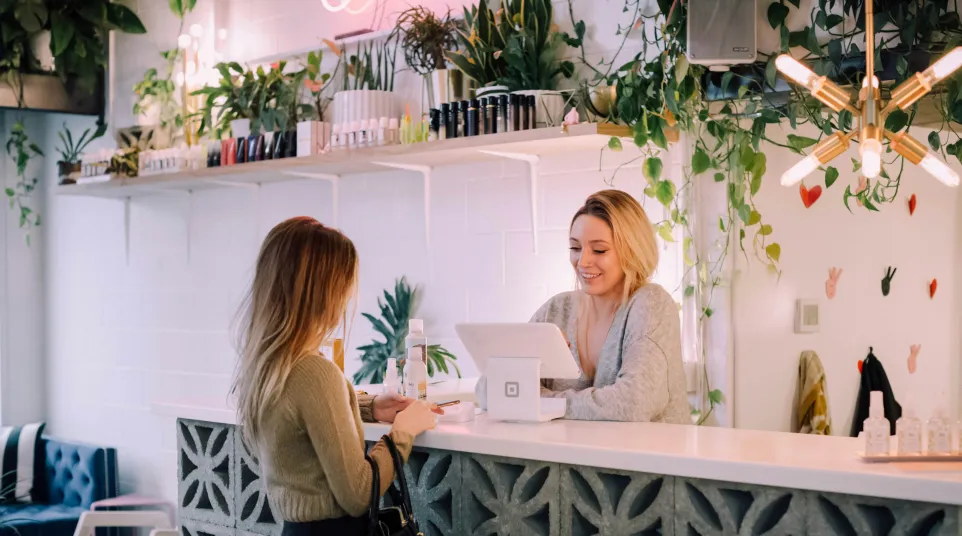 a woman showing a woman something on the computer