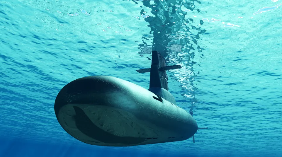 Submarine cruising underwater with light rays penetrating the clear blue ocean surface.
