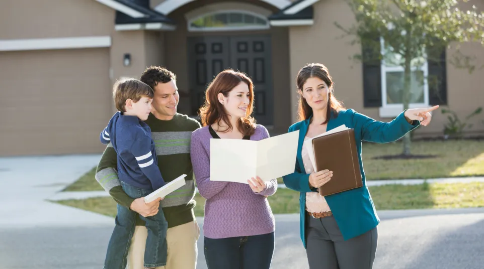 A family engages with a realtor in a bright, welcoming home setting.