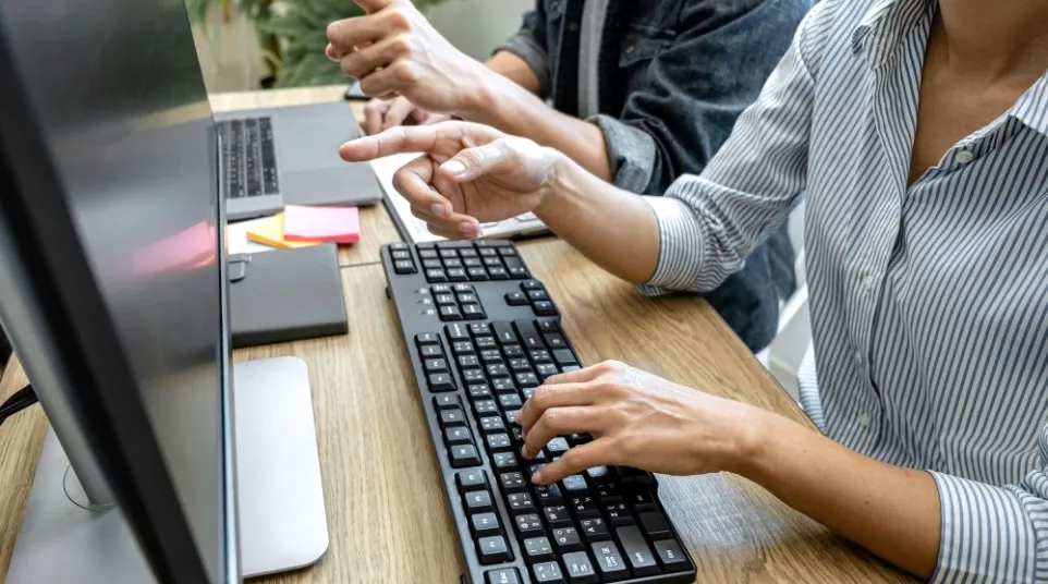 a man and a woman working on a computer