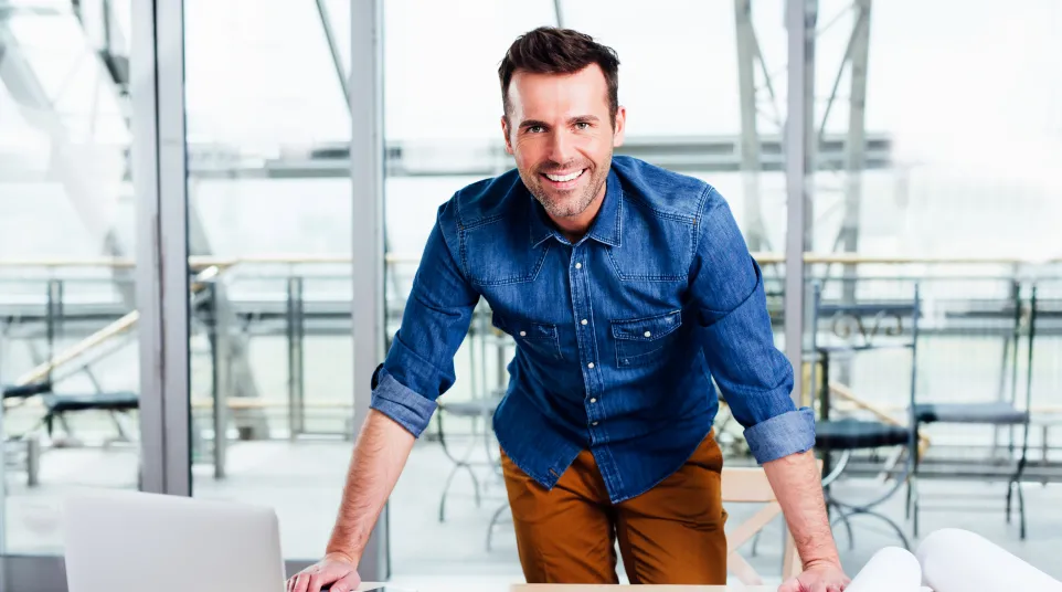 a man standing next to a laptop