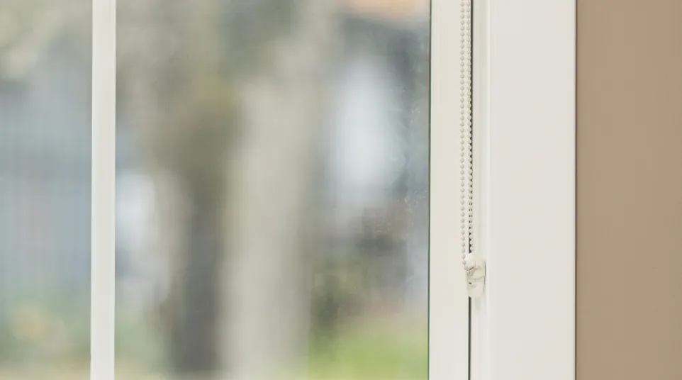 a window with a view of a field and trees outside