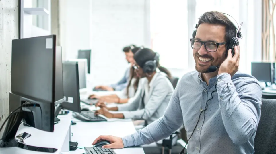 a person wearing headphones and sitting at a desk with a computer