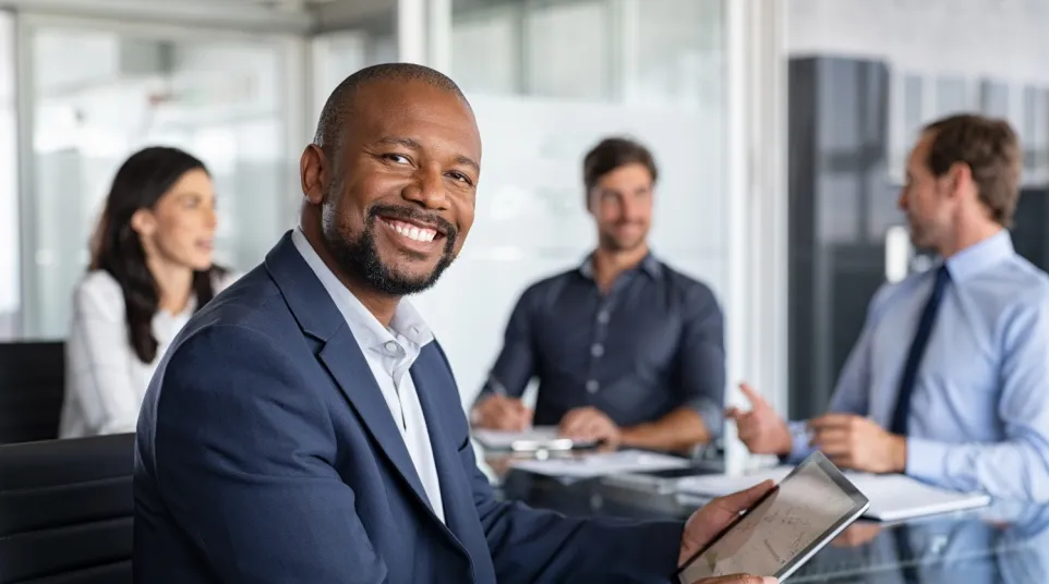 a man smiling and holding a tablet