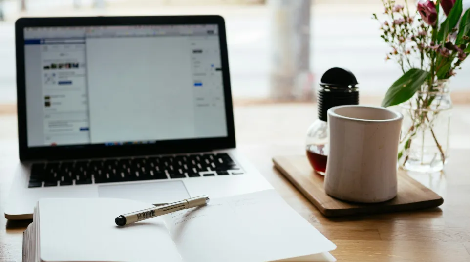 a laptop and a pen on a table