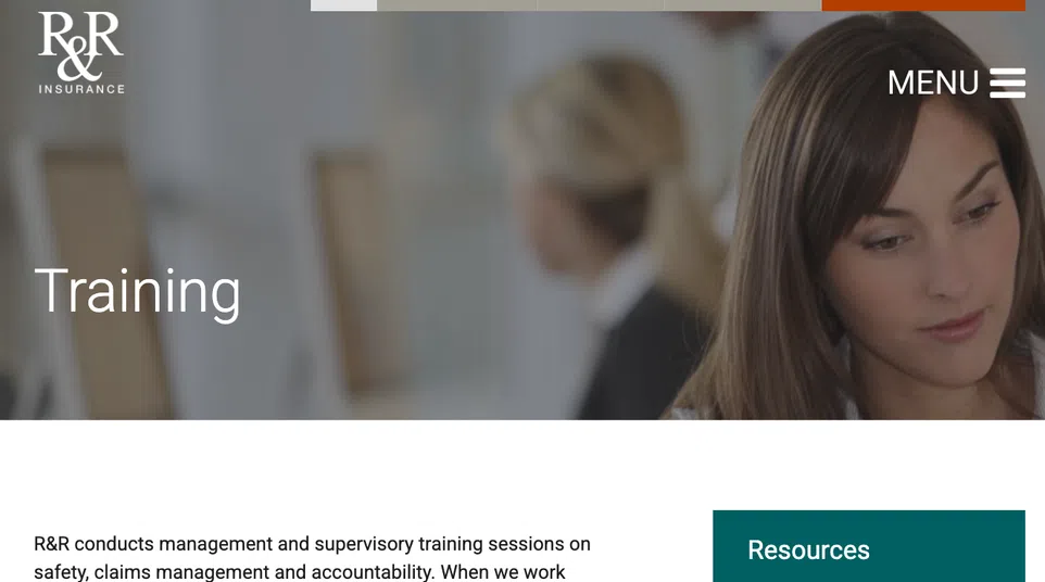 Woman focusing on training session content with blurred colleagues in background on insurance website.