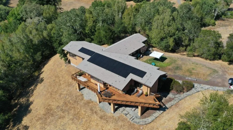 a house with a roof surrounded by trees