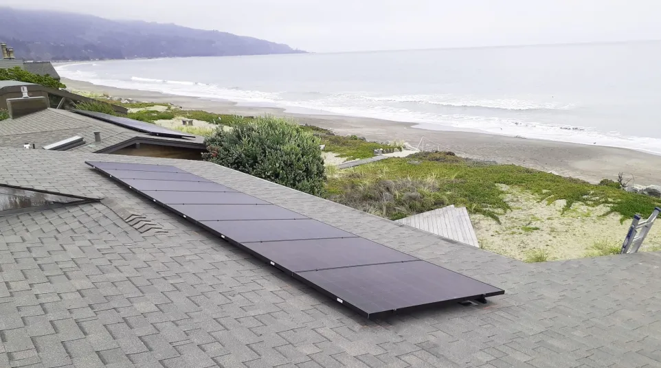 a roof with solar panels on it by a beach