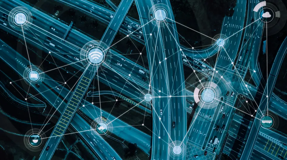 Aerial view of a complex highway network with digital connectivity icons overlaid.