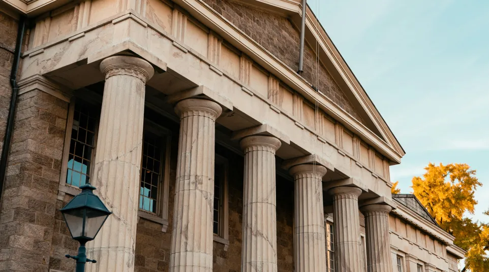 a building with columns and a flag on top