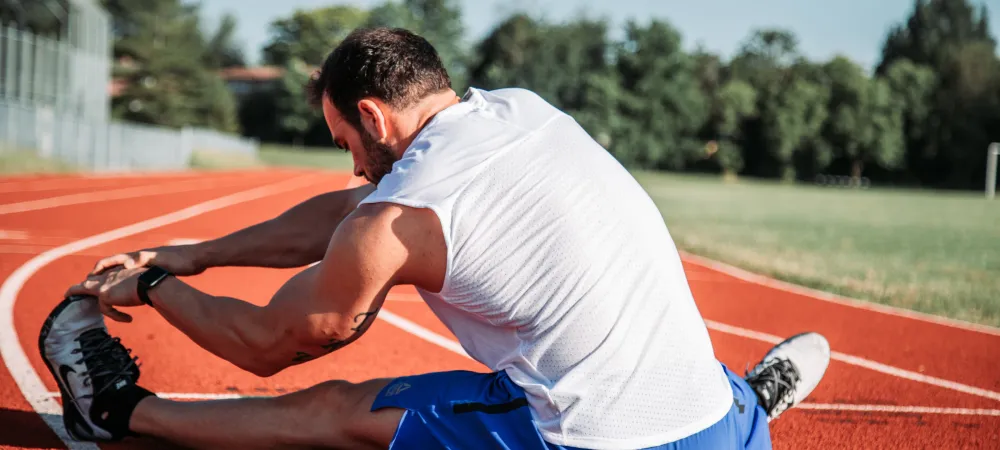 a man stretching on a track.