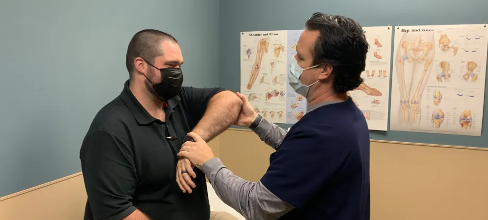 Injured elbow being examined by Matthew Revennaugh.