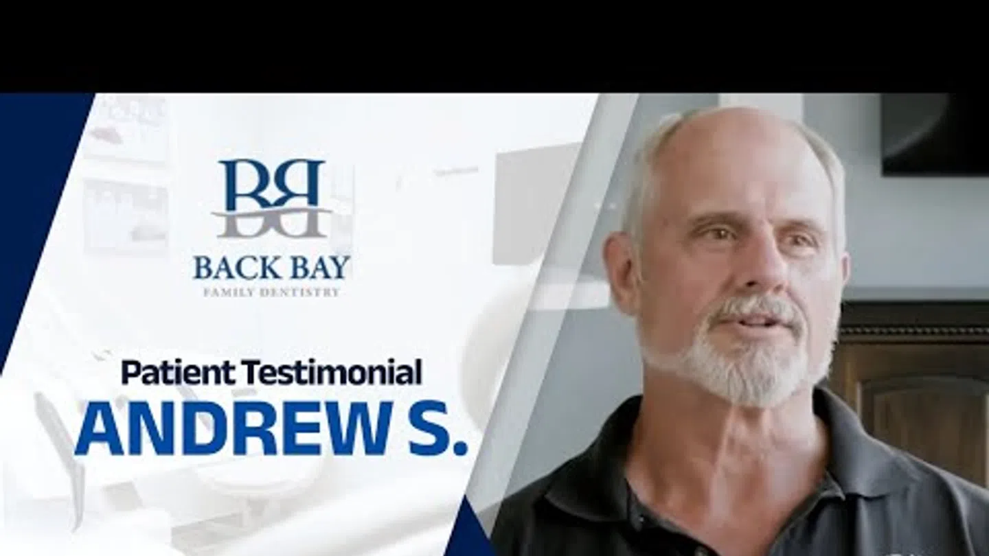 Smiling older man sharing his testimonial for Back Bay Family Dentistry with logo and name Andrew S.