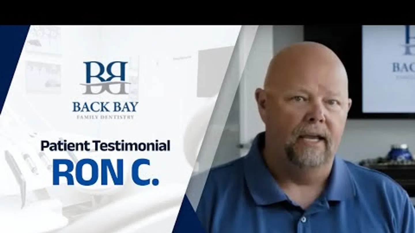 Middle-aged man sharing a patient testimonial for Back Bay Family Dentistry in a professional setting.