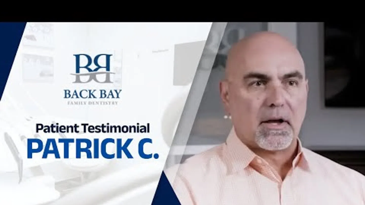 Middle-aged man giving a patient testimonial for Back Bay Family Dentistry in a professional setting.