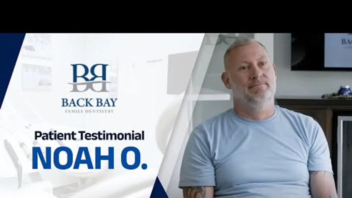 Patient testimonial from Noah O. at Back Bay Family Dentistry with a man sitting and smiling.