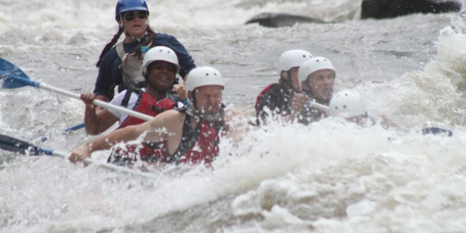 a group of people getting splashed on a raft