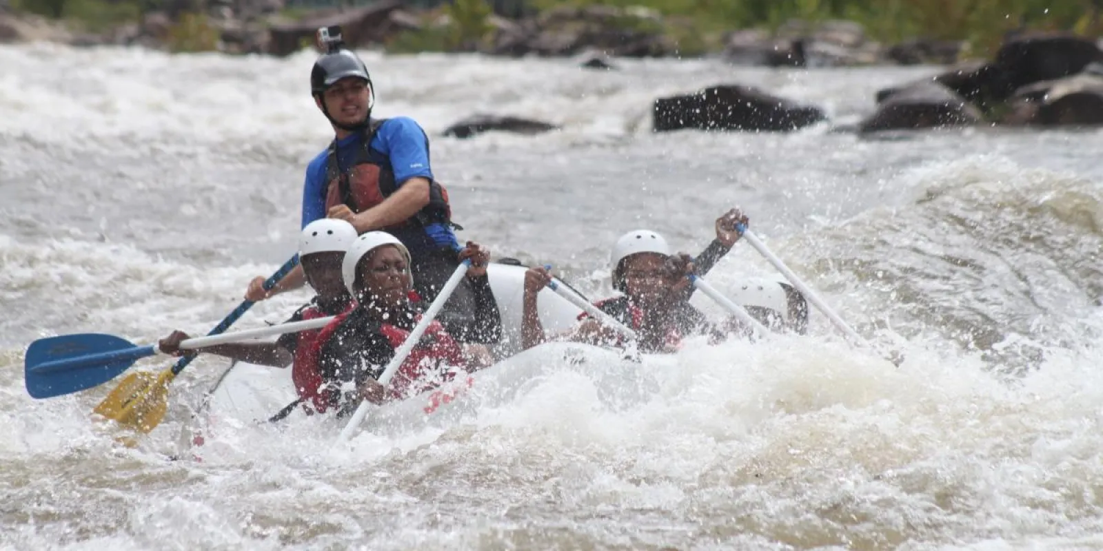 people riding in a raft on the rapids