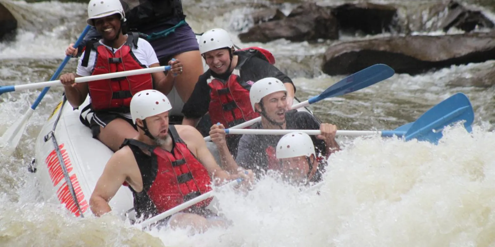 a group of people riding through rough waves