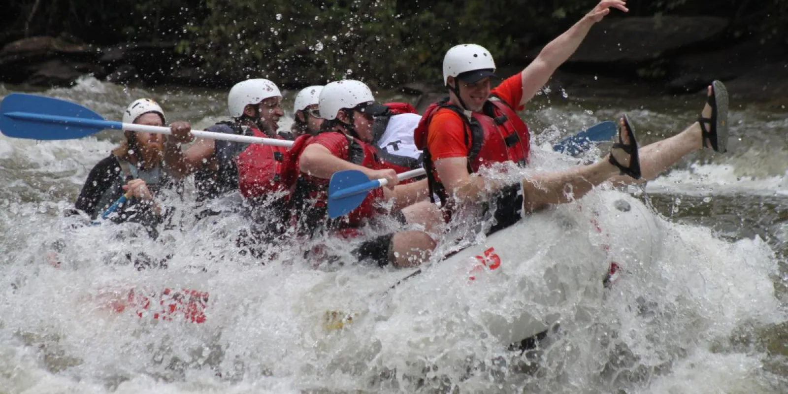 a group of people riding on a raft in a body of water