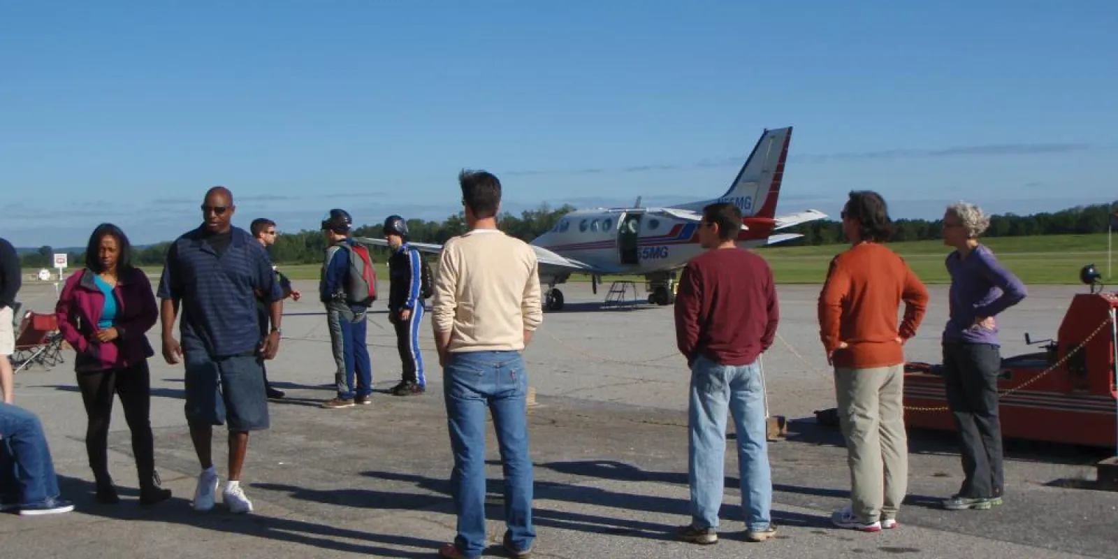 a group of people standing around a plane