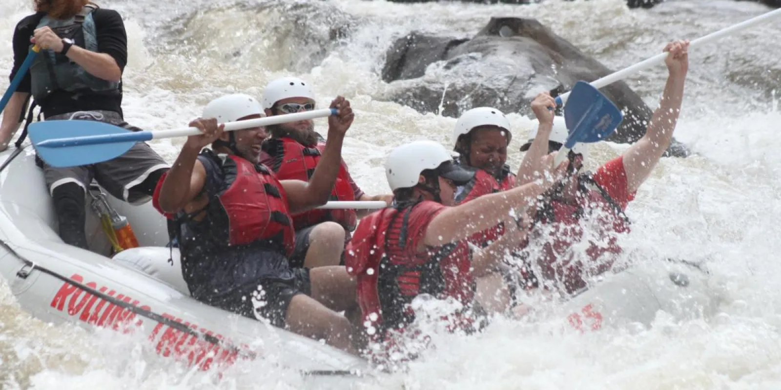 a group of people riding on the rapids in a raft