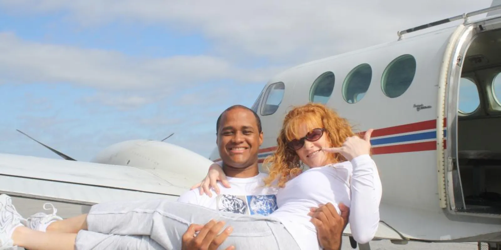 Two people in front of a plane