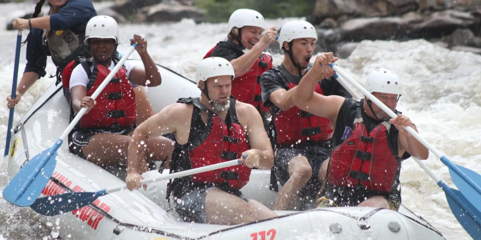 a group of people on a raft in rapids