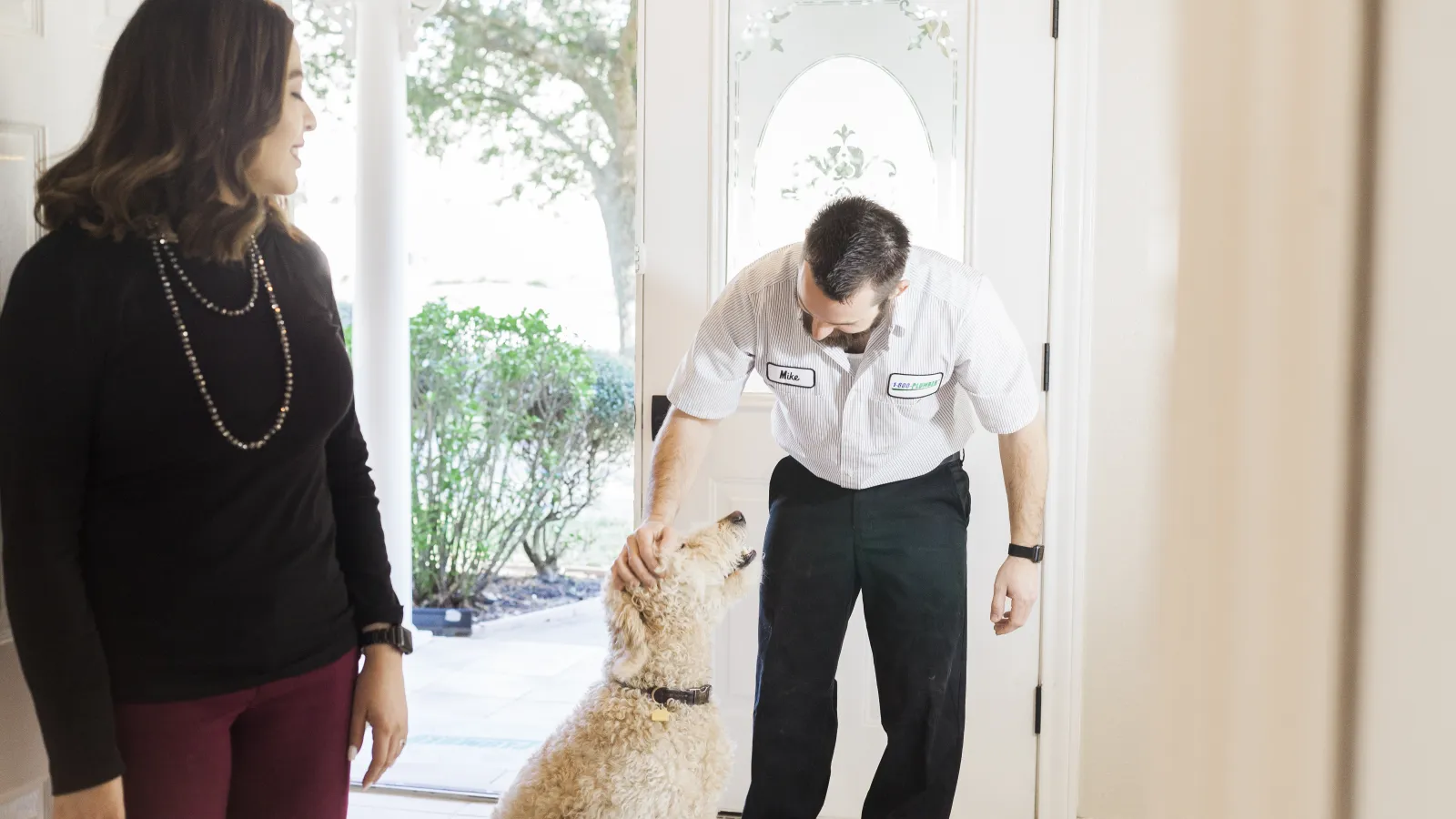 a man and a woman standing next to a dog