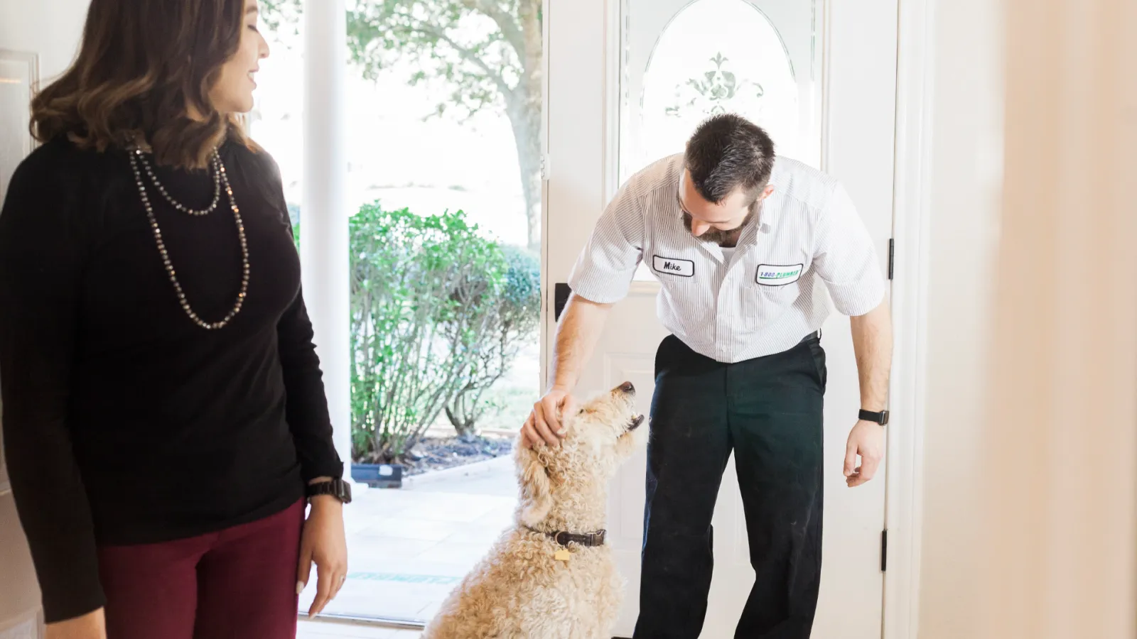 a man and a woman standing next to a dog