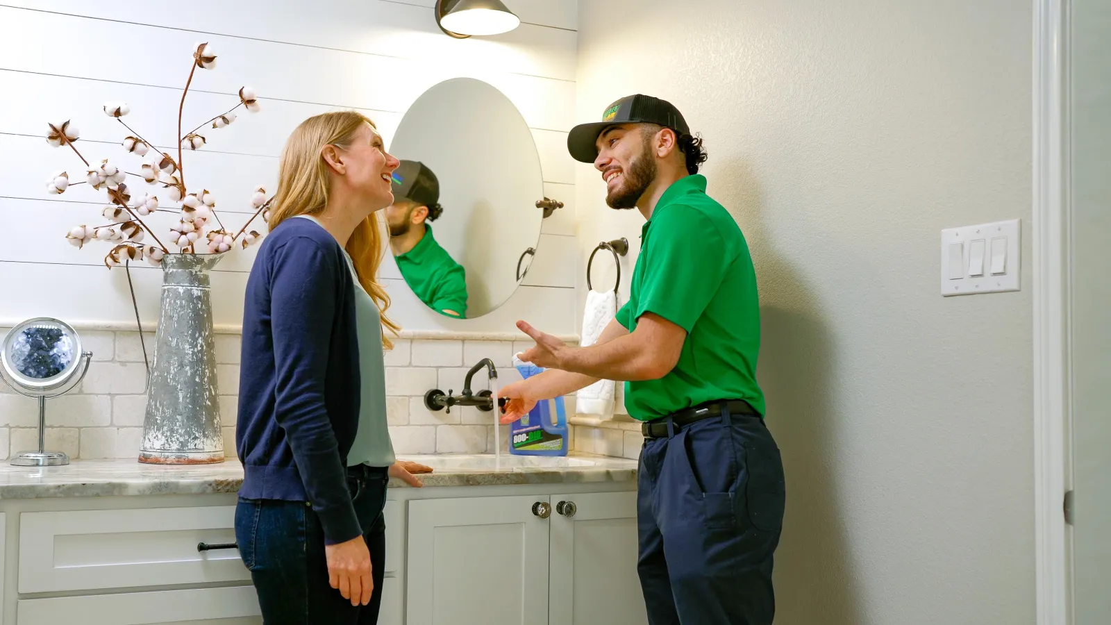 A New Port Richey plumber and a homeowner next to a kitchen sink