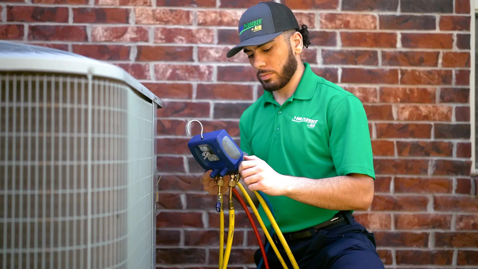A 1-800-Plumber +Air of Greenville cooling technician repairs an outside ac unit