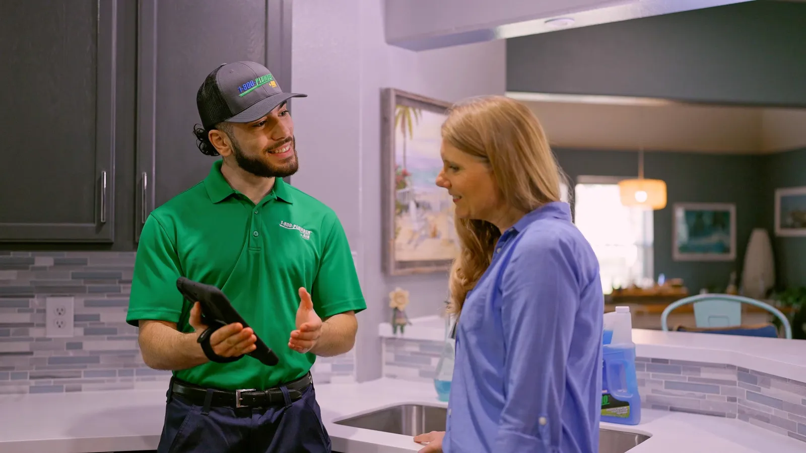 A Houston plumbing technician talks to a homeowner