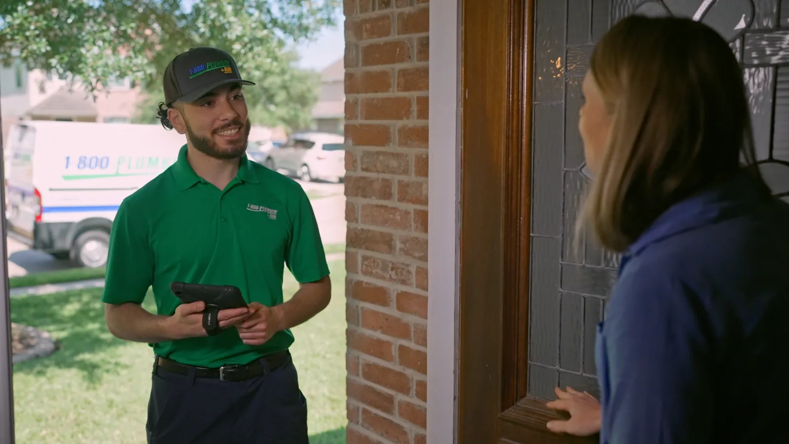 1-800-Plumber +Air technician at customer's front door