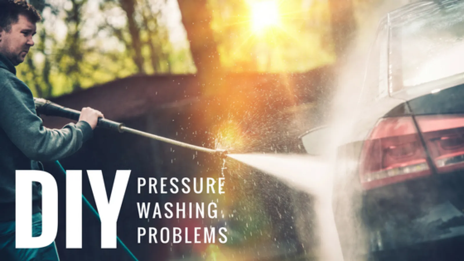 a man pressure washing a car