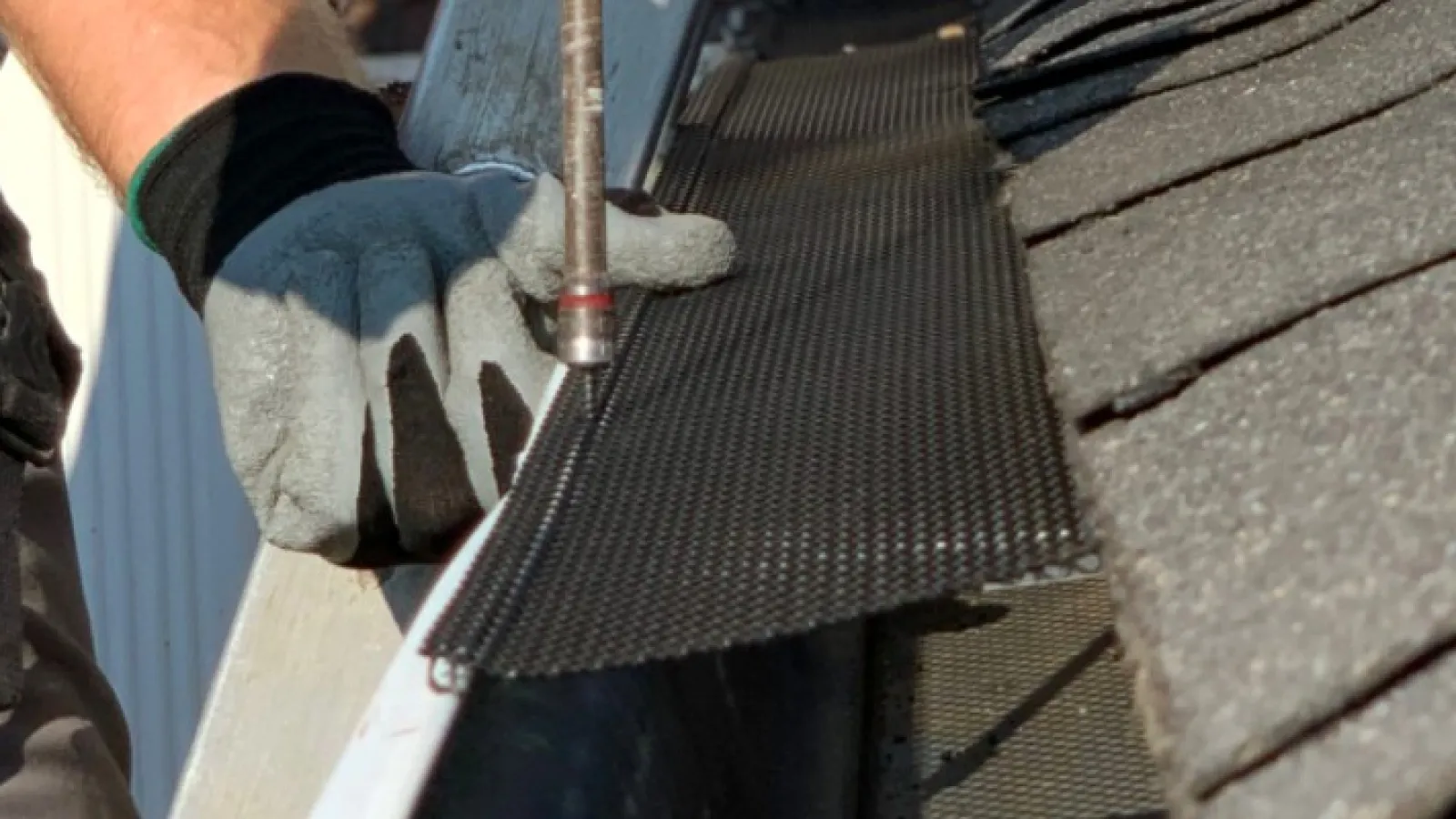 a person installing a gutter cover