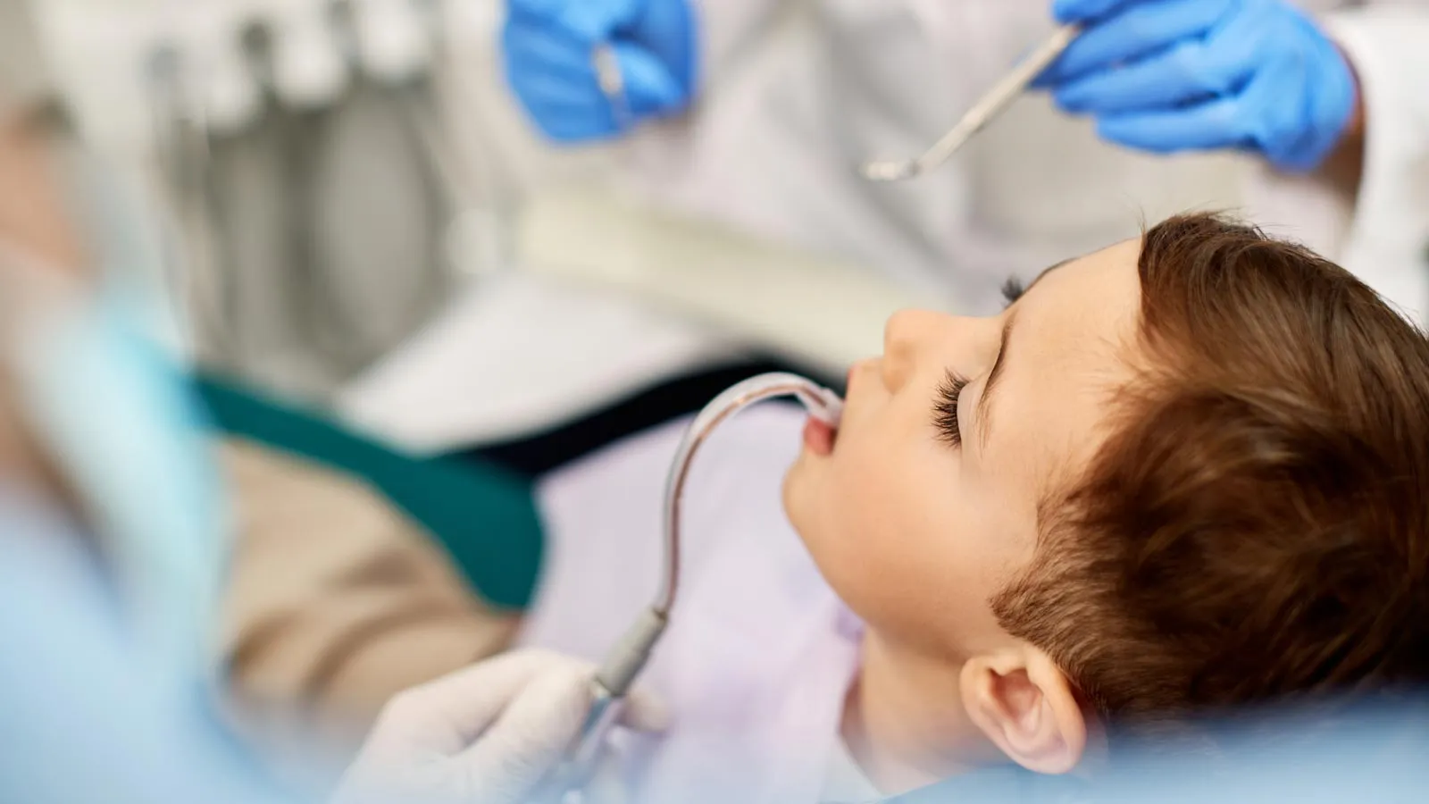 a dentist examining a child patient